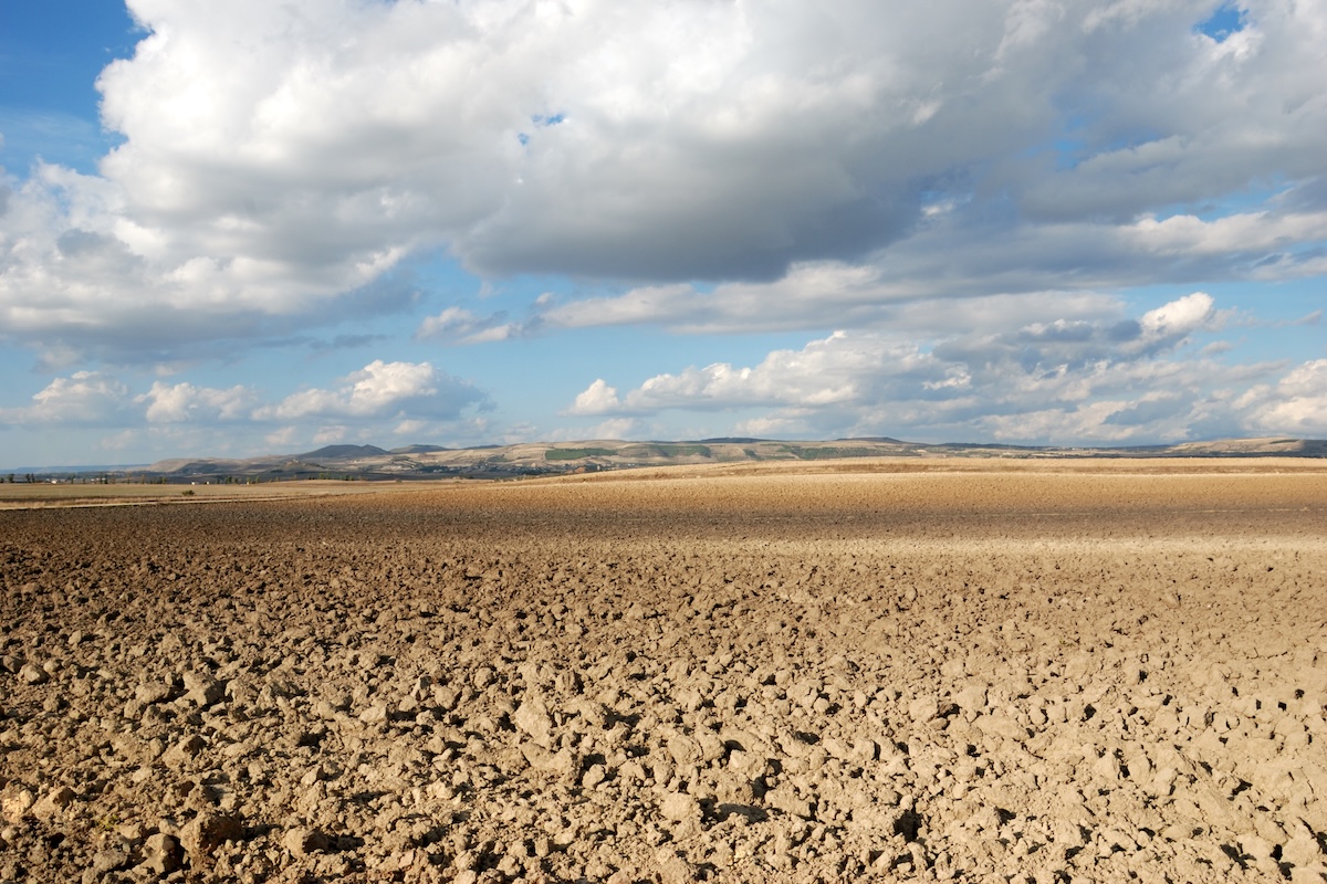 Terreno arato e nuvole: al Forum si parlerà di come affrontare il cambiamento climatico