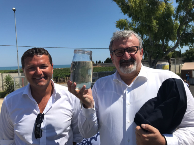 A destra, il presidente della Regione Puglia, Michele Emiliano, mostra la trasparenza dell'acqua affinata nel nuovo depuratore di Barletta