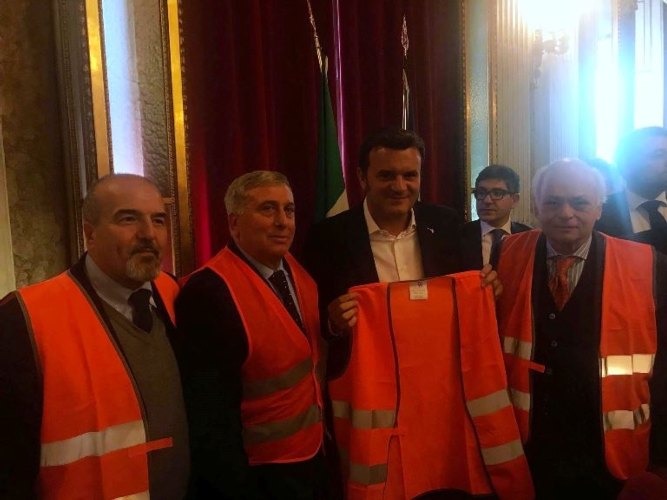 Il ministro Centinaio esibisce un gilet arancione, simbolo della protesta degli olivicoltori pugliesi
